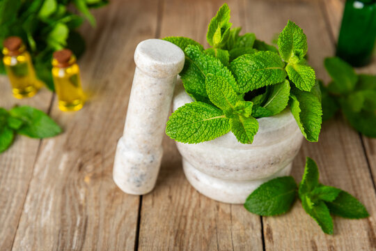 Cucumber water with lemon, lime and mint on a wooden table. Water infused with sliced ​​cucumber in a drinking glass. Tonic refreshing drink. Cucumber lemonade.Summer natural cooling drink.Copy space