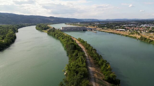Bourg les Valence, France - 2 August 2025: Drone aerial panorama of CNR hydroelectric power plant on the Rhone River renewable green energy infrastructure with dam water flow turbines.