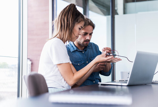 Team collaborating with electronics and laptop in modern office