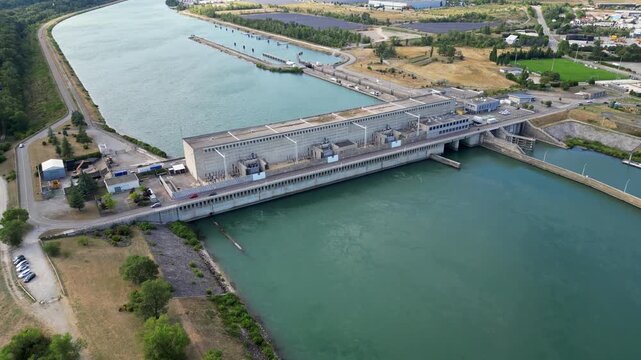 Bourg les Valence, France - 2 August 2025: Drone aerial panorama of CNR hydroelectric power plant on the Rhone River renewable green energy infrastructure with dam water flow turbines.