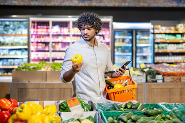 Person carefully choosing vibrant vegetables while shopping in a well-lit supermarket produce section, illustrating a modern lifestyle and healthy eating habits.