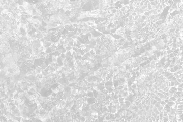 White water with ripples on the surface. Defocus blurred transparent white colored clear calm water surface texture with splashes and bubbles. Water waves with shining pattern texture background.
