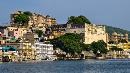 Fototapeta premium Scenic view from the water of the historic city of Udaipur with its palaces and traditional architecture along the banks of Lake Pichola, Rajasthan, India, August 2025.