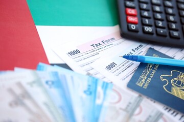 United Arab Emirates dirham money bills and calculator with tax form on flag. Taxation and...