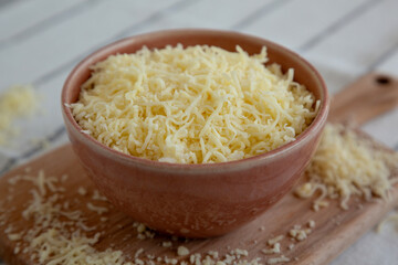 Organic Grated Cheese Mix in a Bowl, side view. Close-up.