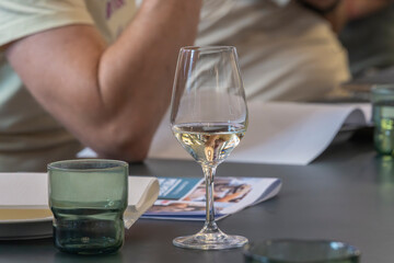 White wine glass at conference table, pair and writing utensils