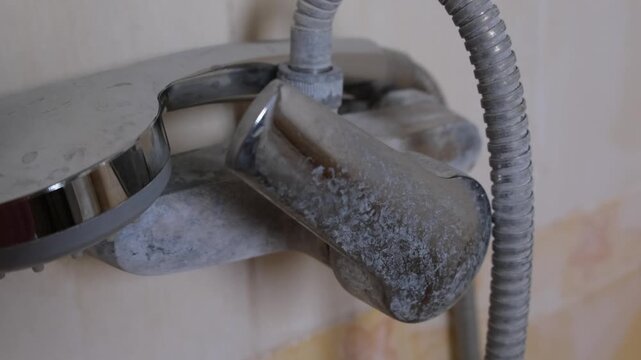 Shower faucet with limescale from hard water, scale close-up