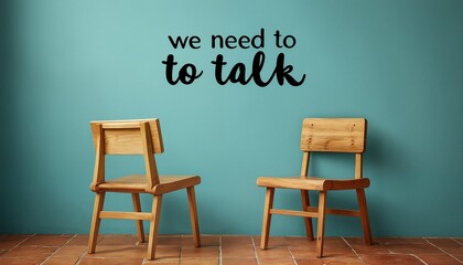 a poignant scene depicts two small wooden chairs facing each other against a teal wall displaying the phrase "we need to talk", suggesting a difficult conversation or confrontation.