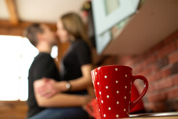Red polka dot mug with kissing couple in background
