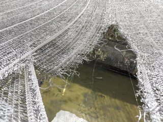 The net made of black plastic or shading net is a protector from the hot sun, which is torn