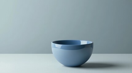 Minimal gray-blue ceramic bowl placed on light surface for elegant kitchenware product concept