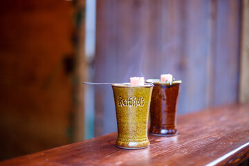 Traditional German Feuerzangenbowle in ceramic mugs with burning sugar cubes at festive winter market
