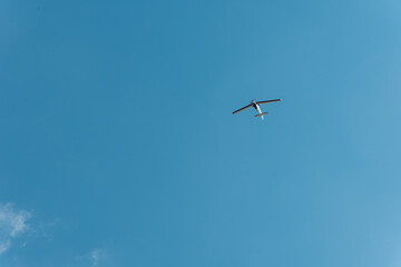 Airplane flying in clear blue sky with large minimal background
