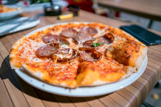 Fototapeta Pizza on the table of a street cafe