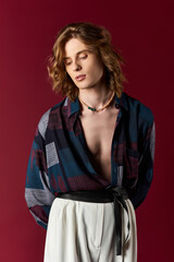 Fototapeta premium Fashionable young man showcases trendy feminine style in an artistic setting