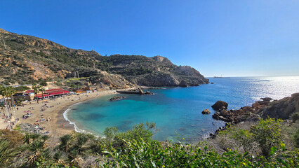 Naklejka premium Coastal Beach with Hills, Restaurants, and Blue Water