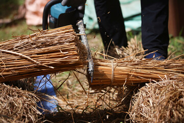 茅束を切る男性 © yamasan