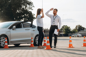 High five, you passed. Woman is trying to pass exam in the driving school