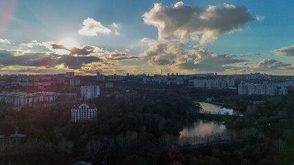 Aerial city view with residential buildings park and lake at sunset sunrise