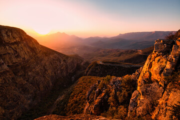 Sunset view from Leba Pass over the Leba Desert – vertical cliff and glowing horizon with mountain silhouettes in Angola