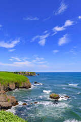 北海道浜中町、琵琶瀬から望む嶮暮帰島（けんぼっきとう）。7月の青空と太平洋の青い海が広がる爽やかな夏の風景。澄み切った空気と美しい水平線が魅力的な景色
