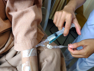 Patients receive injections or treatment through an IV drip administered by a nurse to hospital patients.