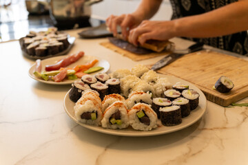 Delicious Homemade Sushi Rolls with Fresh Ingredients and sashimi on a Kitchen Counter