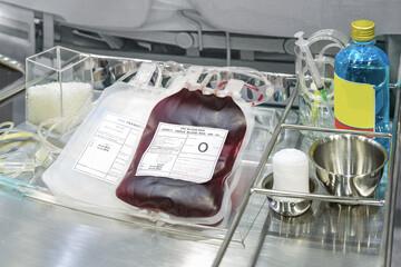 Blood bag donation on storage trolley inside hospital room.
