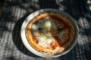 Margherita pizza served on outdoor table