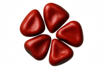 Glossy red triangular candies forming circular floral pattern against clean transparent surface