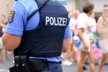 German police officer on duty in public place, uniformed policeman patrolling streets, public...
