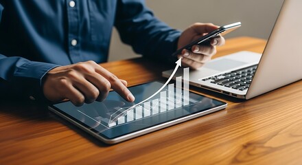 Analyzing business growth trends on a digital tablet and laptop with a smartphone