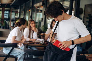 Notepad is in hand. Group of young friends are in the cafe restaurant
