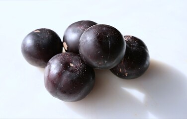 Close-up of ripe round plums with deep purple skin. This aromatic and flavorful variety stands out for its juicy texture and sweet taste. Ideal for food, health, and harvest concepts.