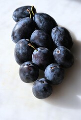 Close-up of fresh dark blue plums, showcasing variety and natural texture. Ideal for botanical publications, horticulture studies, fruit cultivation articles, and gardening magazines.