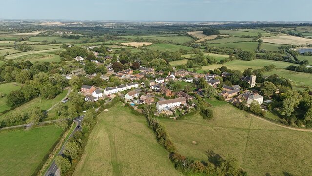 Aerial drone shot of rural village, residential houses and green fields, in Leicestershire England UK