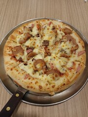 Delicious Meaty Pizza on a Metal Pan with a Rustic Wooden Background