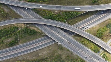Aerial drone shot of busy motorway junction intersection with numerous bridges and lanes and vehicles near Rugby England UK M1 highway 