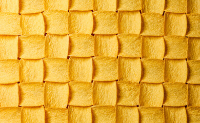 Yellow potato chips pattern with light from left
