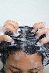 Naklejka premium A woman takes a shower and washes her hair in the bathroom at home.