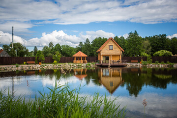 Fototapeta premium A house is next to a pond with a wooden dock