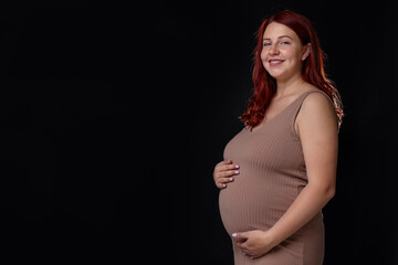 Fototapeta na wymiar Beautiful pregnant woman on black background, space for text