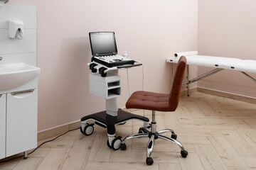 Modern ultrasound machine, chair and examination bed in clinic