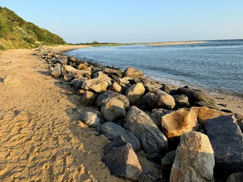 Beautiful golden hour sunrise on the beach at Kings Park Bluffs and Sunken Meadow State Park in Smithtown, NY at dawn. Hot, summer day. Clear, no clouds.  Blue sky, coastline of Long Island Sound.