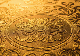 Close-up of a luxurious golden fabric with an ornate embossed pattern
