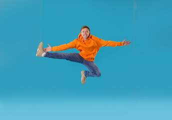 Obraz premium Happy young man jumping on light blue background