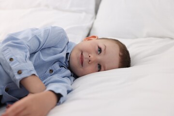 Smiling little boy on bed at home