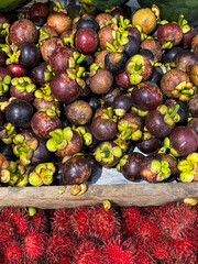 Tropical bounty of vibrant mangosteens and rambutan, invoking Lunar New Year abundance, exotic market vitality, jungle harvest