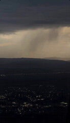 Moody twilight rain shower over tranquil townscape, embracing Umbrella Day reveries and Tempest Nostalgia Festival's serene anticipation