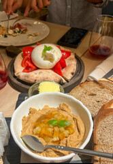 Succulent burrata pizza and caramelized hummus beckon in Mediterranean feast, perfect for Roman Saturnalia or World Tapas Day celebration